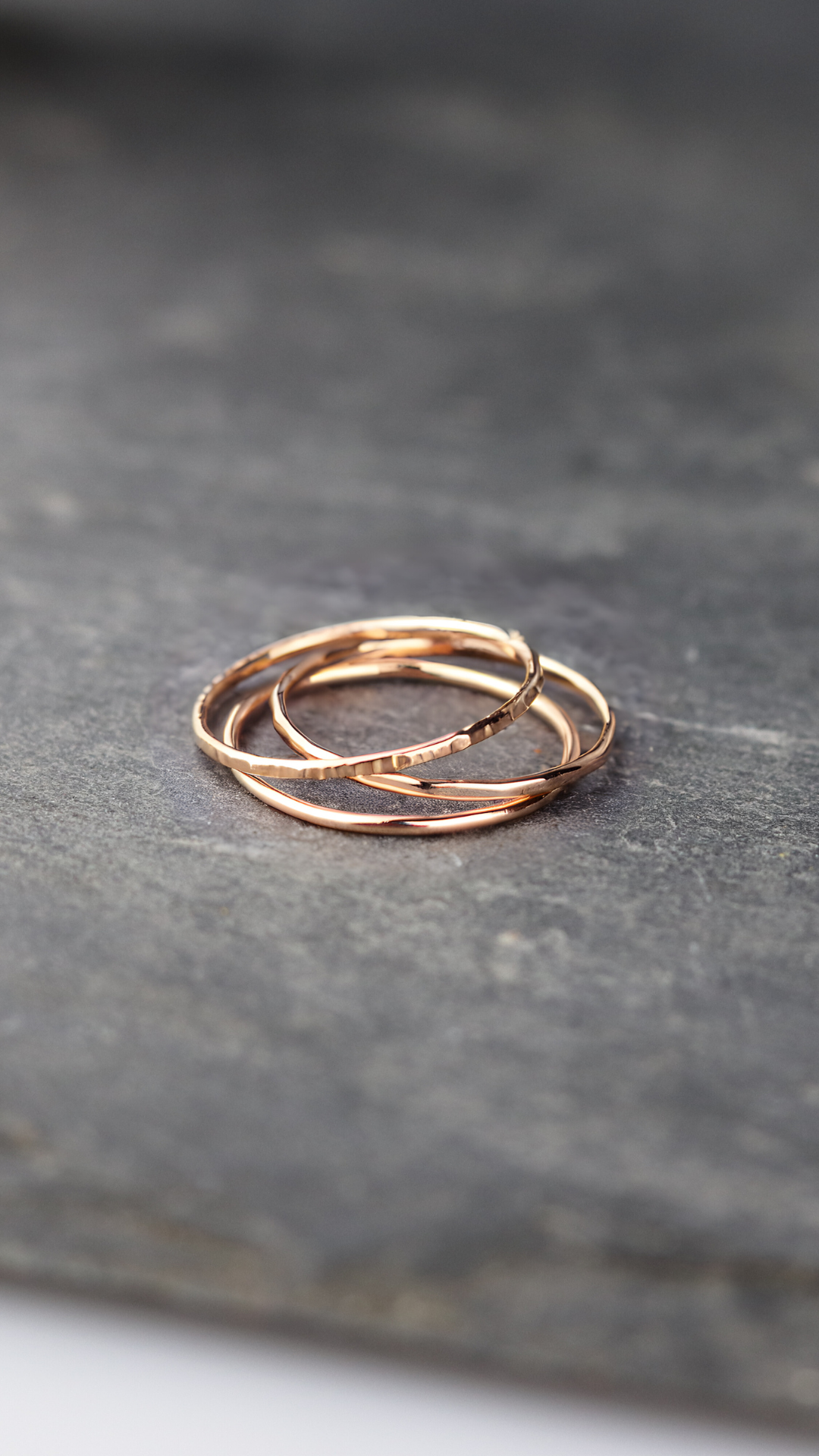 3 Bagues fines or rose 750/1000 lisse ciselée ou martelée posées sur une ardoise naturelle