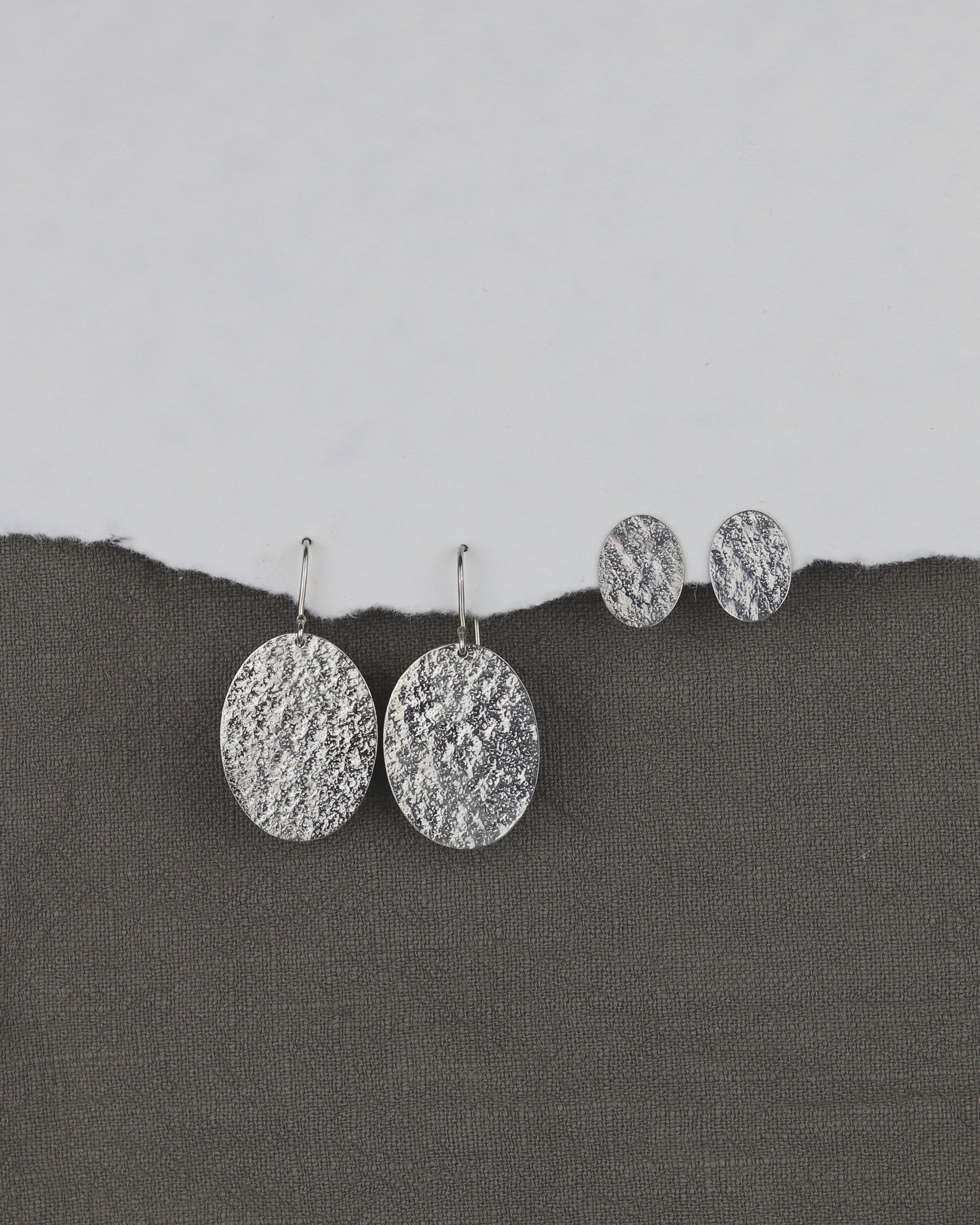 bijoux marion chappaz en argent 925 boucles d'oreilles texturées dormeuses ovales pendantes Emery pour femme sur fond tissu avec puces Emery