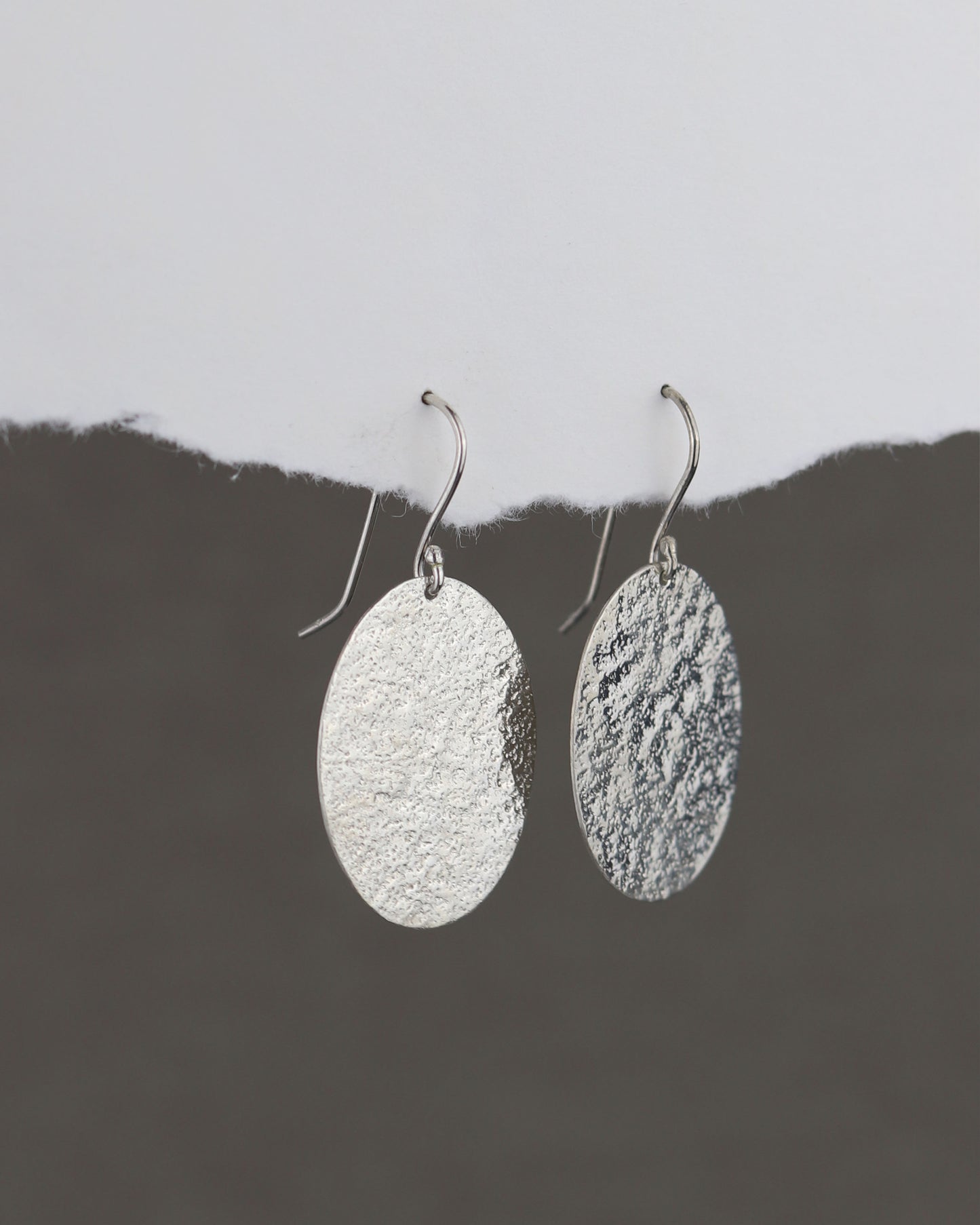 bijoux marion chappaz en argent 925 boucles d'oreilles texturées dormeuses ovales pendantes Emery pour femme sur papier blanc