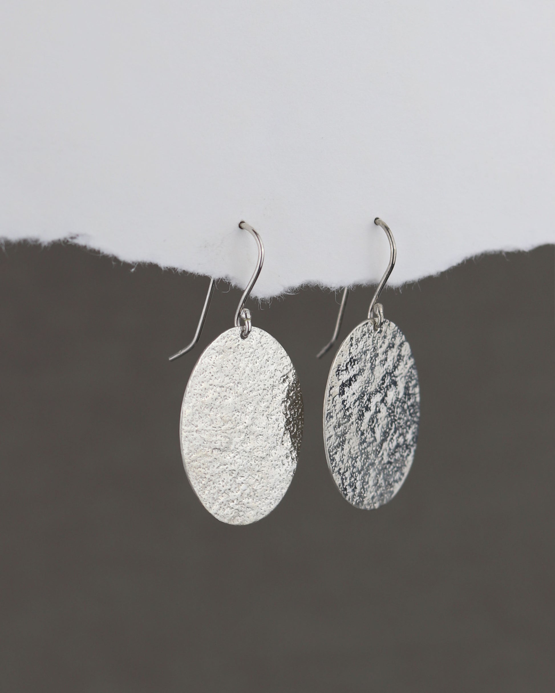 bijoux marion chappaz en argent 925 boucles d'oreilles texturées dormeuses ovales pendantes Emery pour femme sur papier blanc