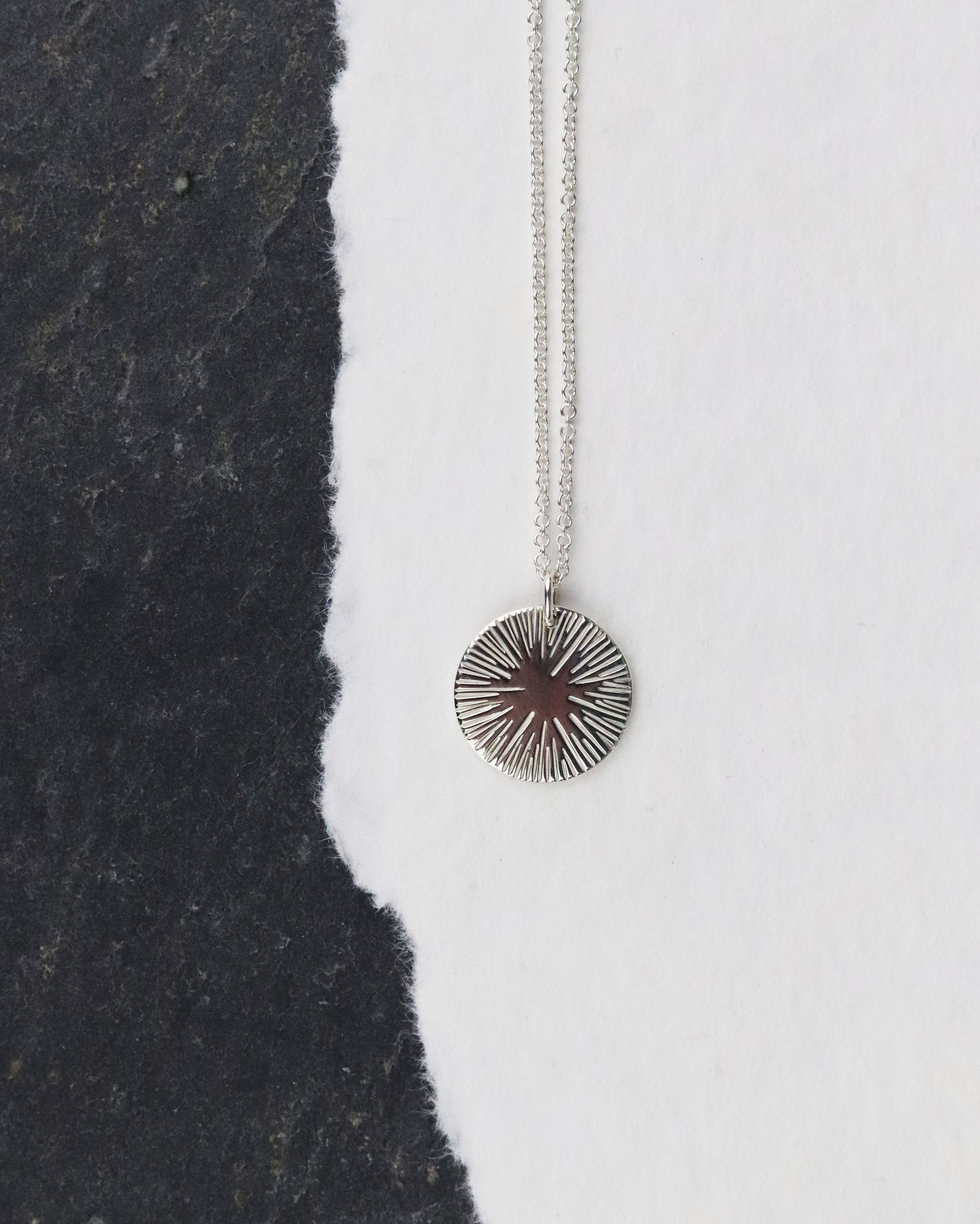bijoux marion chappaz collier argent 925 pour femme médaille soleil taille L sur chaine fine maille forçat ronde posée sur une feuille et fond ardoise