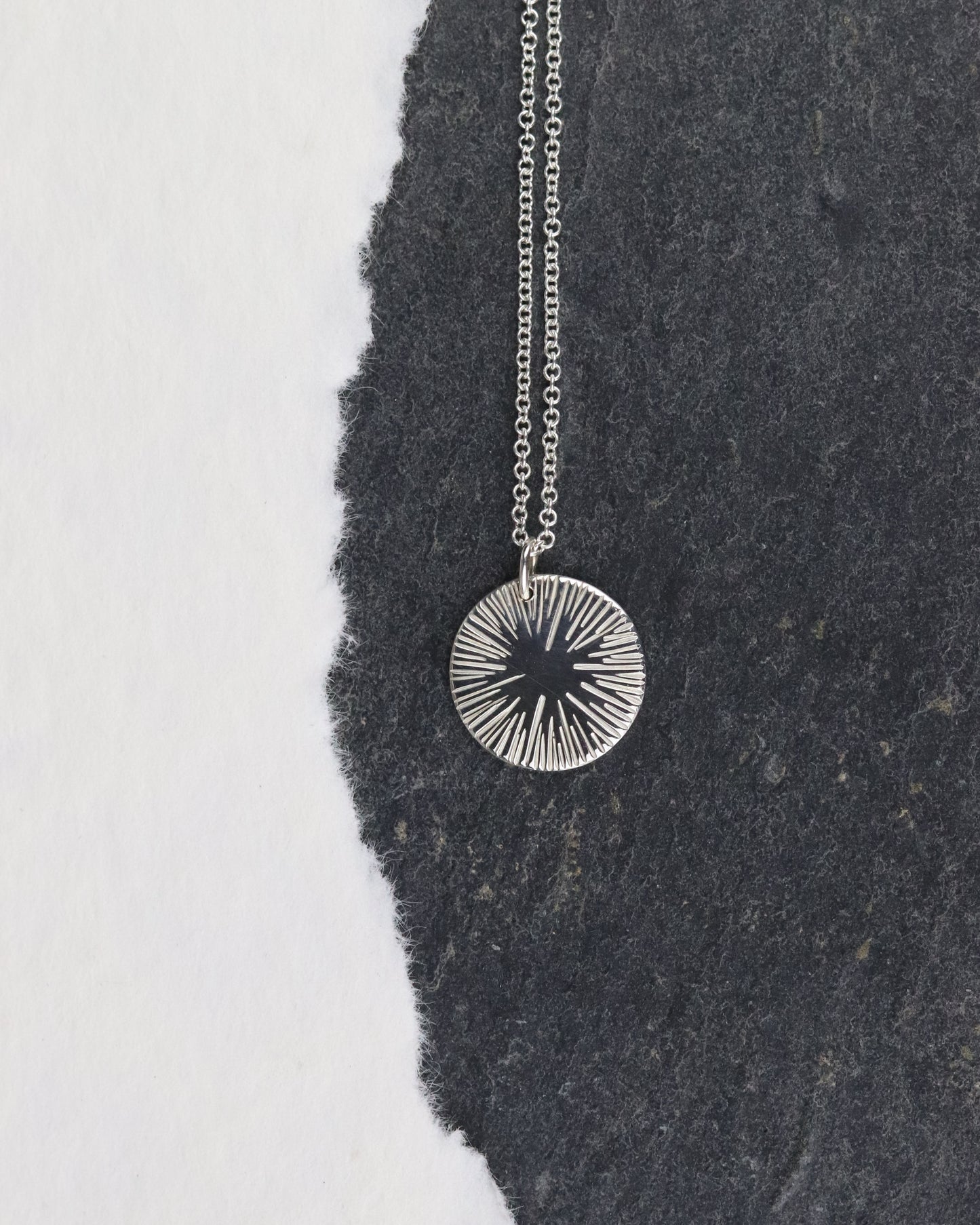 bijoux marion chappaz collier argent 925 pour femme médaille soleil taille L sur chaine fine maille forçat ronde posée sur un fond ardoise