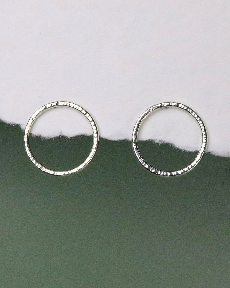 Bijoux Marion Chappaz Boucles d'oreilles Cercles Cirkel ciselées en argent 925 sur support papier blanc et fond vert