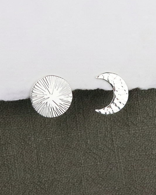 Boucles d'oreilles asymétriques Eclipse Lune Soleil en argent 925 sur fond papier blanc et tissus kaki