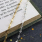 Bracelets Chaine soleil en argent 925/1000 et vermeil posés sur un livre et sur une ardoise naturelle