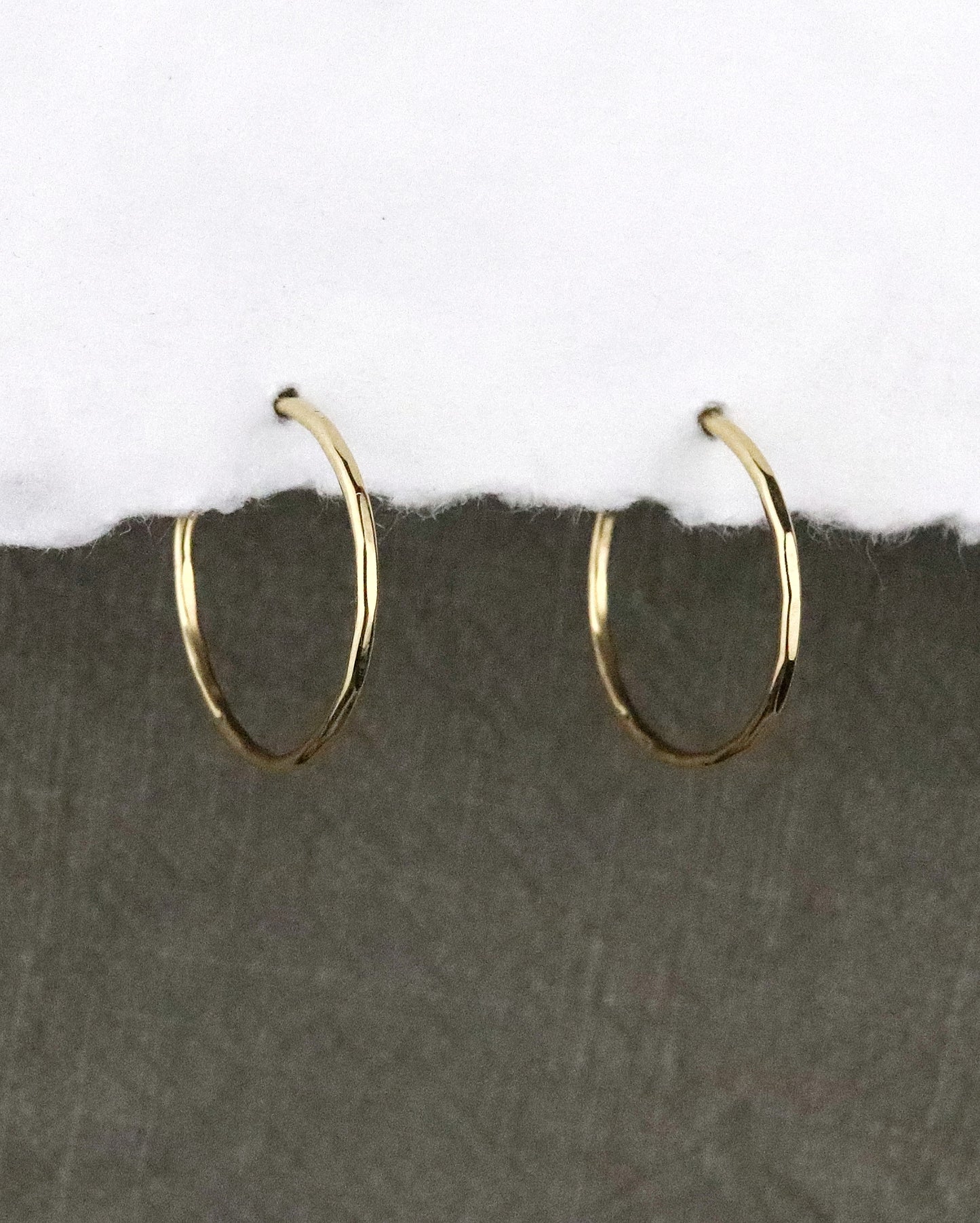 boules d'oreilles créoles fines en vermeil (argent 925/1000 plaqué or 5 microns)taille S martelées sur papier blanc et fond tissu kaki