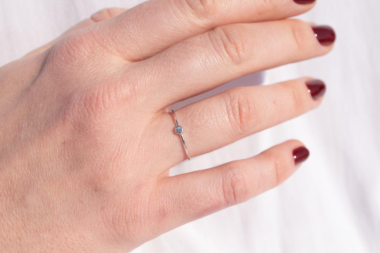 Bijoux Marion Chappaz Bague en argent mini solitaire saphir bleu pâle serti clos portéee