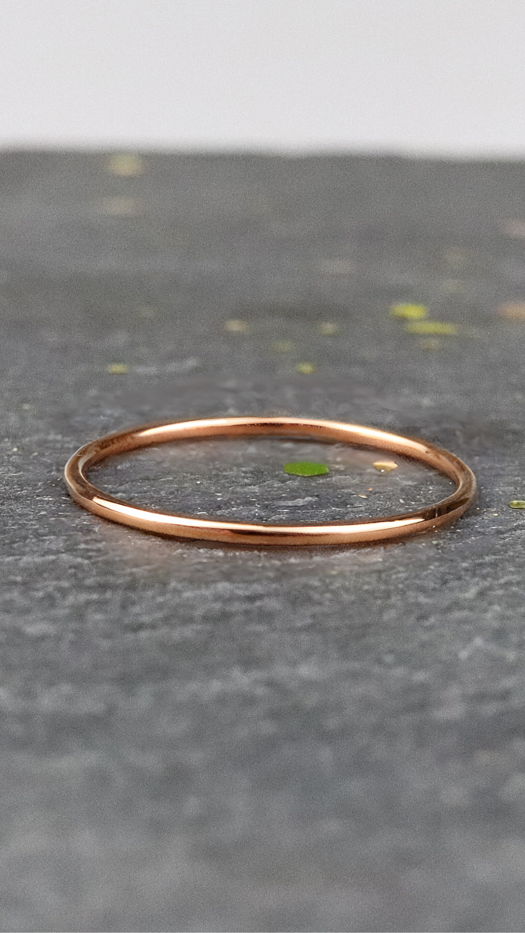 Bague fine or rose 750/1000 lisse posée sur une ardoise naturelle