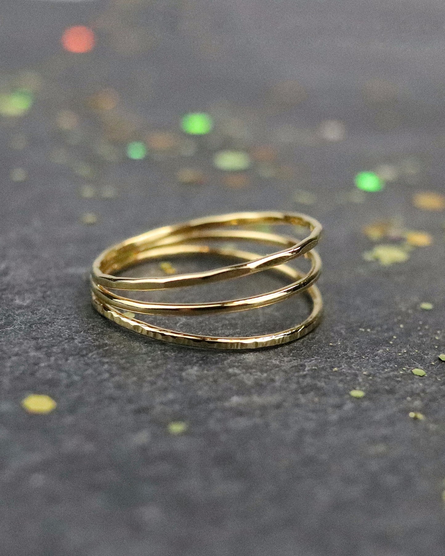 Bague Trio trois anneaux, un lisse, un martelée et un ciselé soudés en une seule bague en vermeil (argent plaqué or 5 microns) sur fond ardoise vue de profil