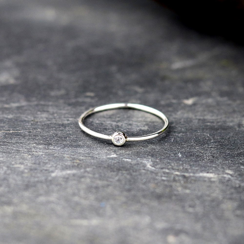 Bijoux Marion Chappaz Bague en argent mini solitaire saphir bleu pâle serti clos sur fond ardoise