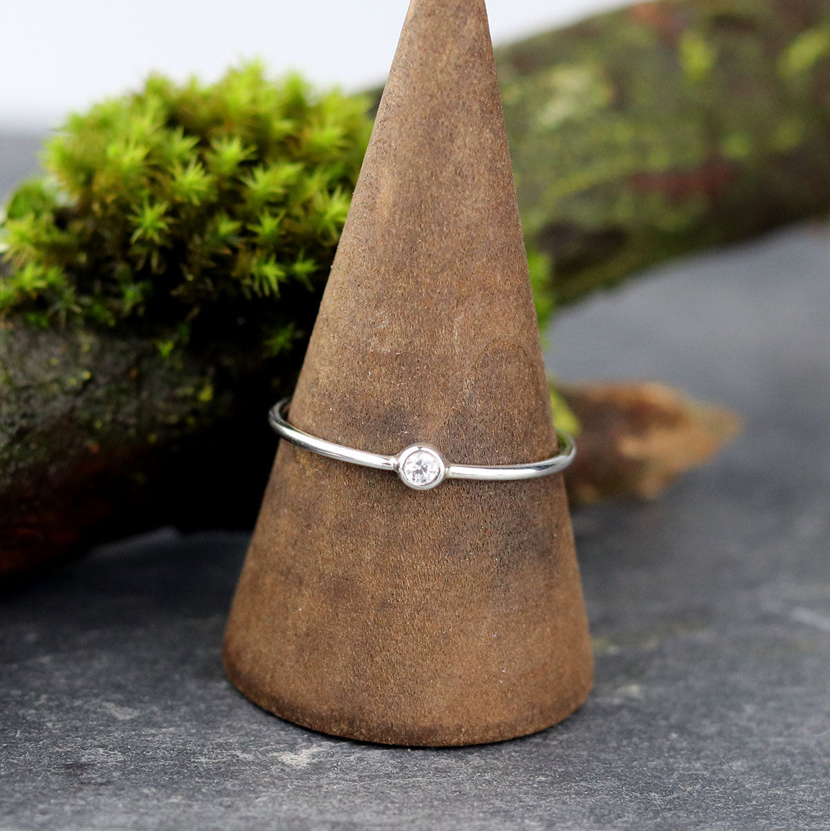 Bijoux Marion Chappaz Bague en argent mini solitaire saphir bleu pâle serti clos sur support bois