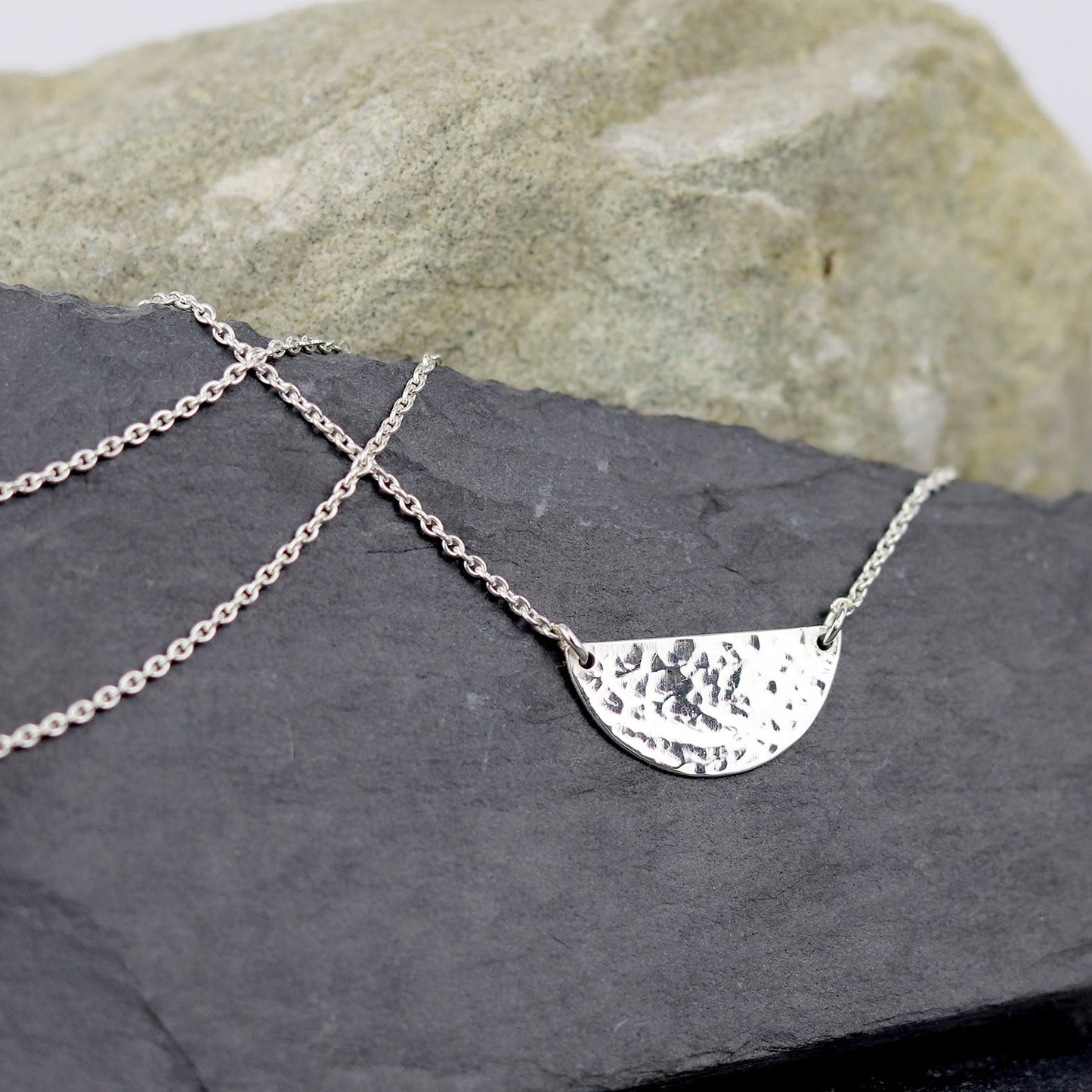 bijoux marion chappaz collier argent 925 demi médaille martelée pour femme posé sur une ardoise naturelle