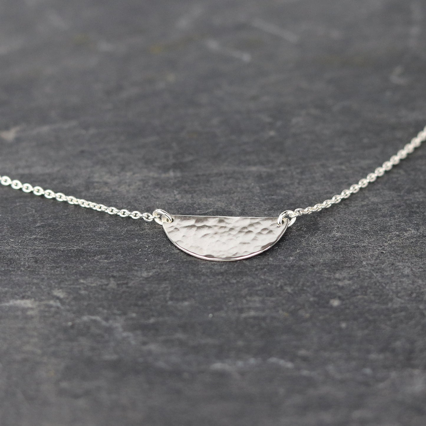 bijoux marion chappaz collier argent 925 demi médaille martelée pour femme posé sur une ardoise naturelle