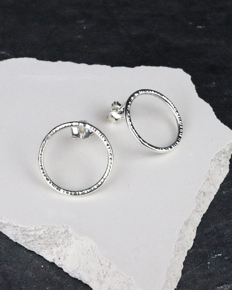 Bijoux Marion Chappaz Boucles d'oreilles Cercles Cirkel ciselées en argent 925 sur support blanc et fond ardoise naturelle