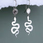 Bijoux Marion Chappaz boucles d'oreilles dormeuses serpent et soleil en argent 925/1000 suspendues sur fond blanc et vert