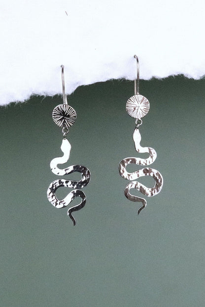 Bijoux Marion Chappaz boucles d'oreilles dormeuses serpent et soleil en argent 925/1000 suspendues sur fond blanc et vert 