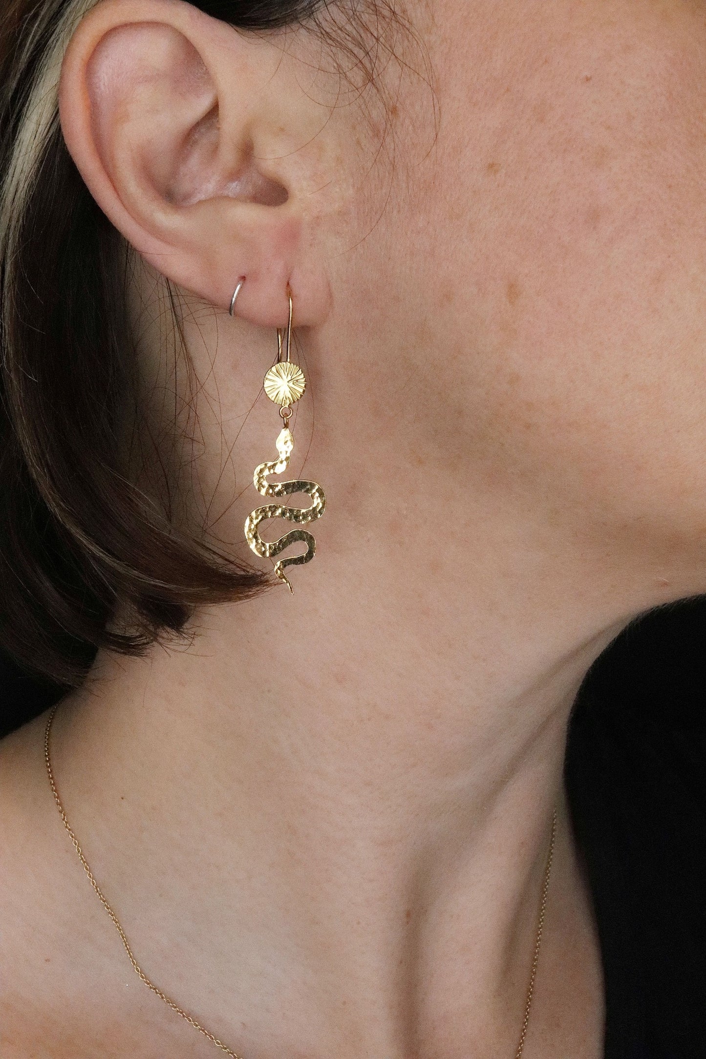 Bijoux Marion Chappaz boucles d'oreilles dormeuses serpent et soleil en vermeil (argent plaqué or) portées par une femme